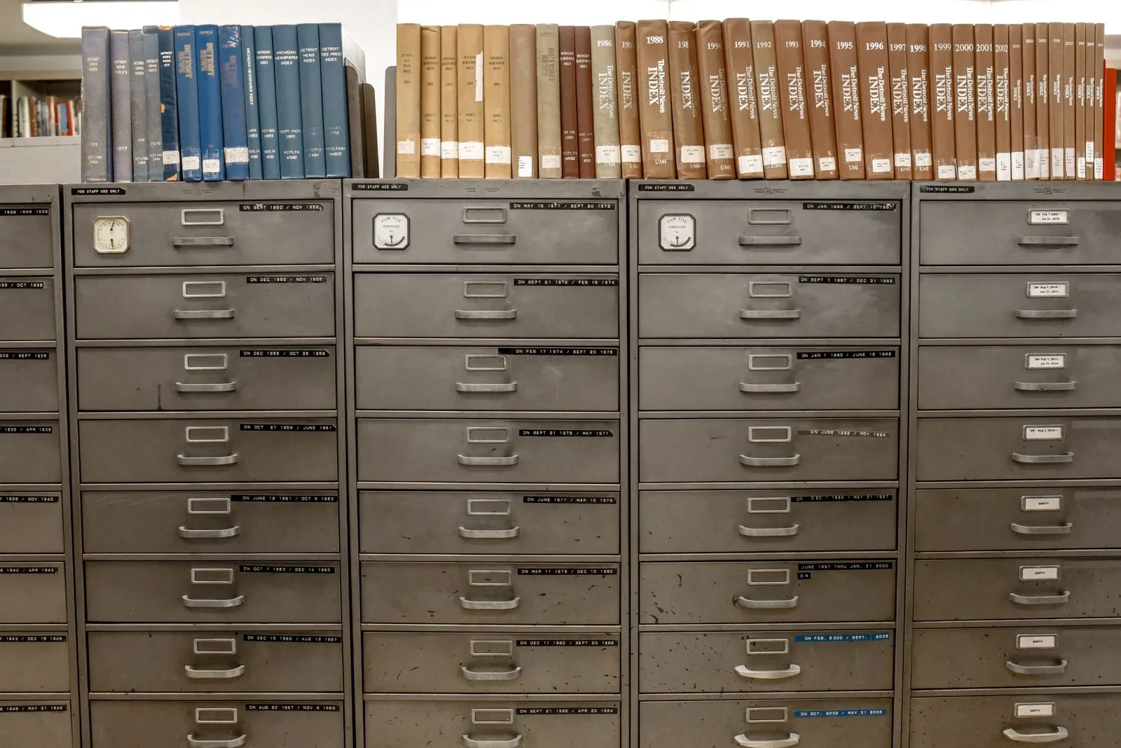 Rows of labeled folders stored in an open metal filing cabinet drawer